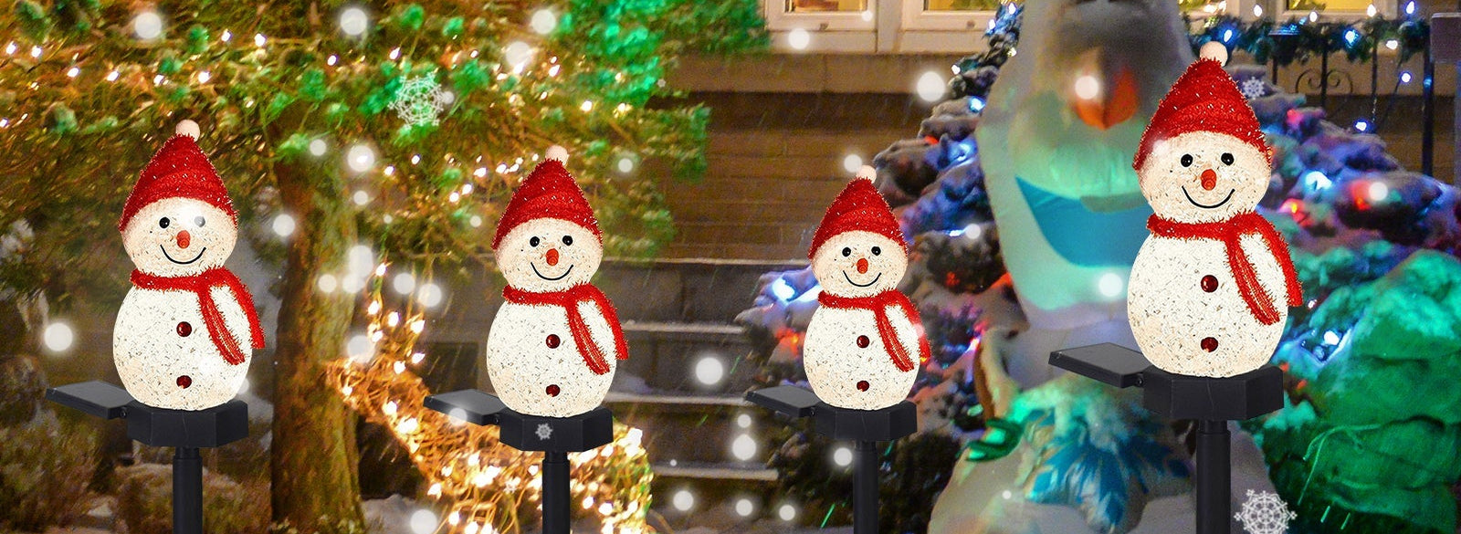 Decorative snowman lights on stakes in front of a house with Christmas trees and lights.